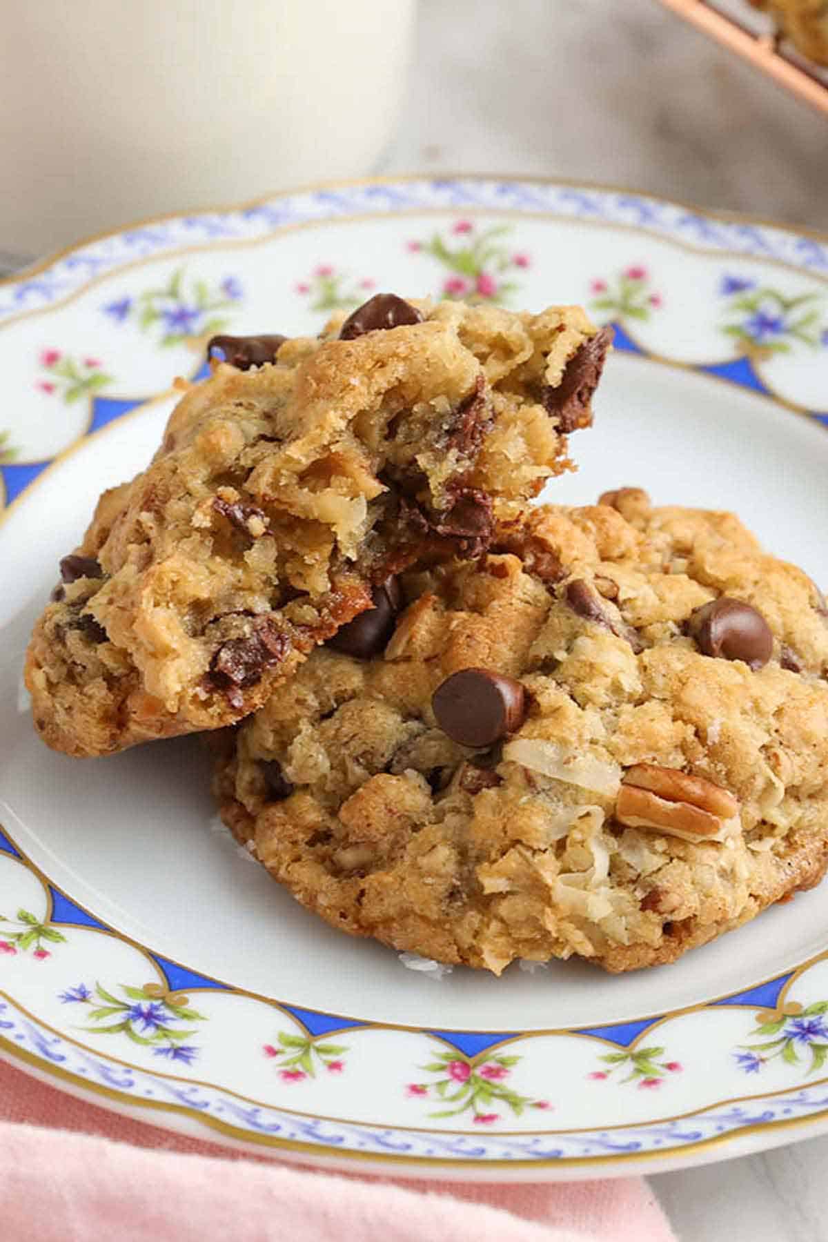 A plate with cowboy cookies on it with one leaning on top of another.