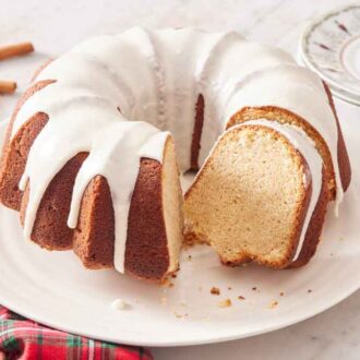 A platter with an eggnog cake with a slice cut out and angled, showing the crumb.