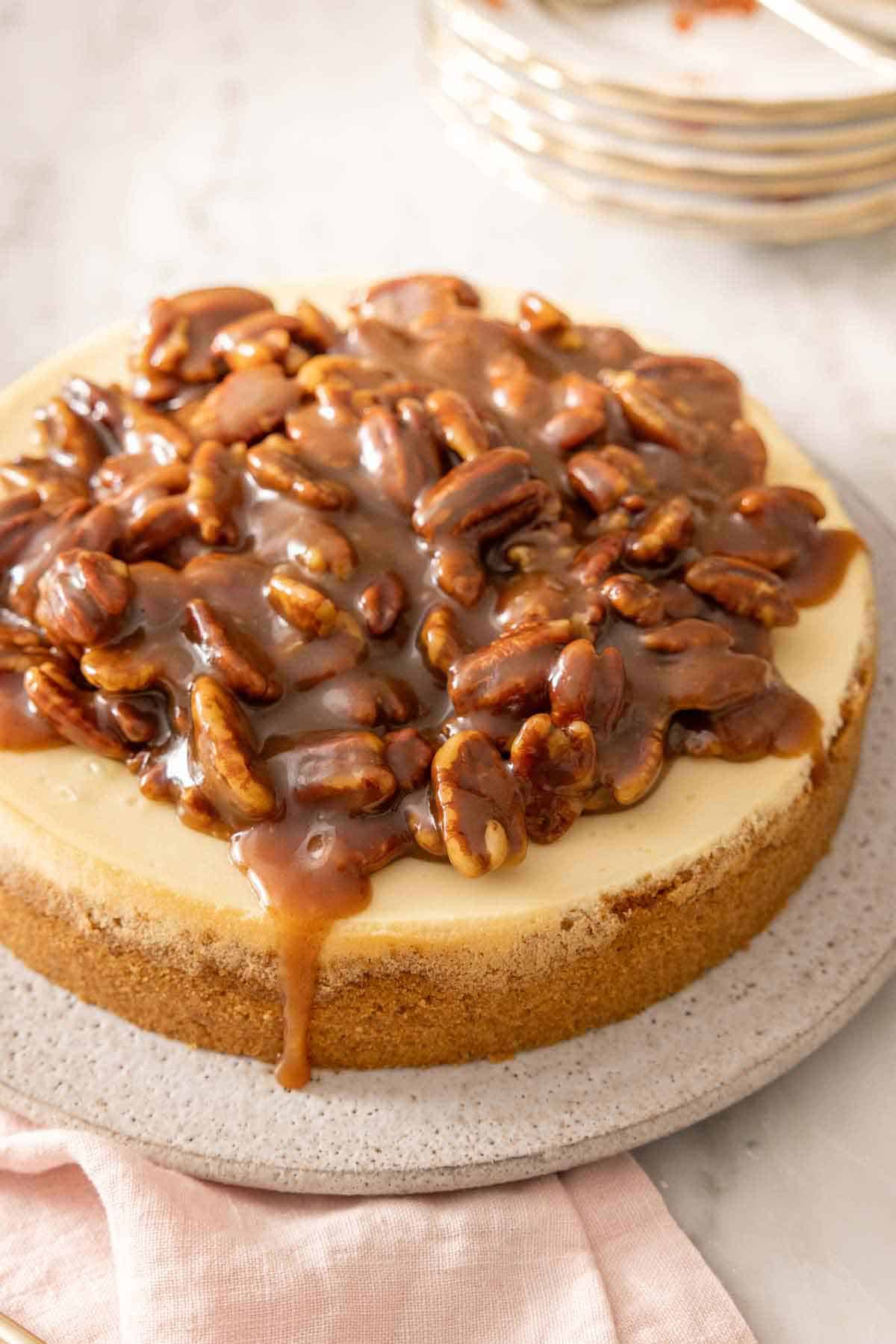 A pecan pie cheesecake with sauce dripping down.