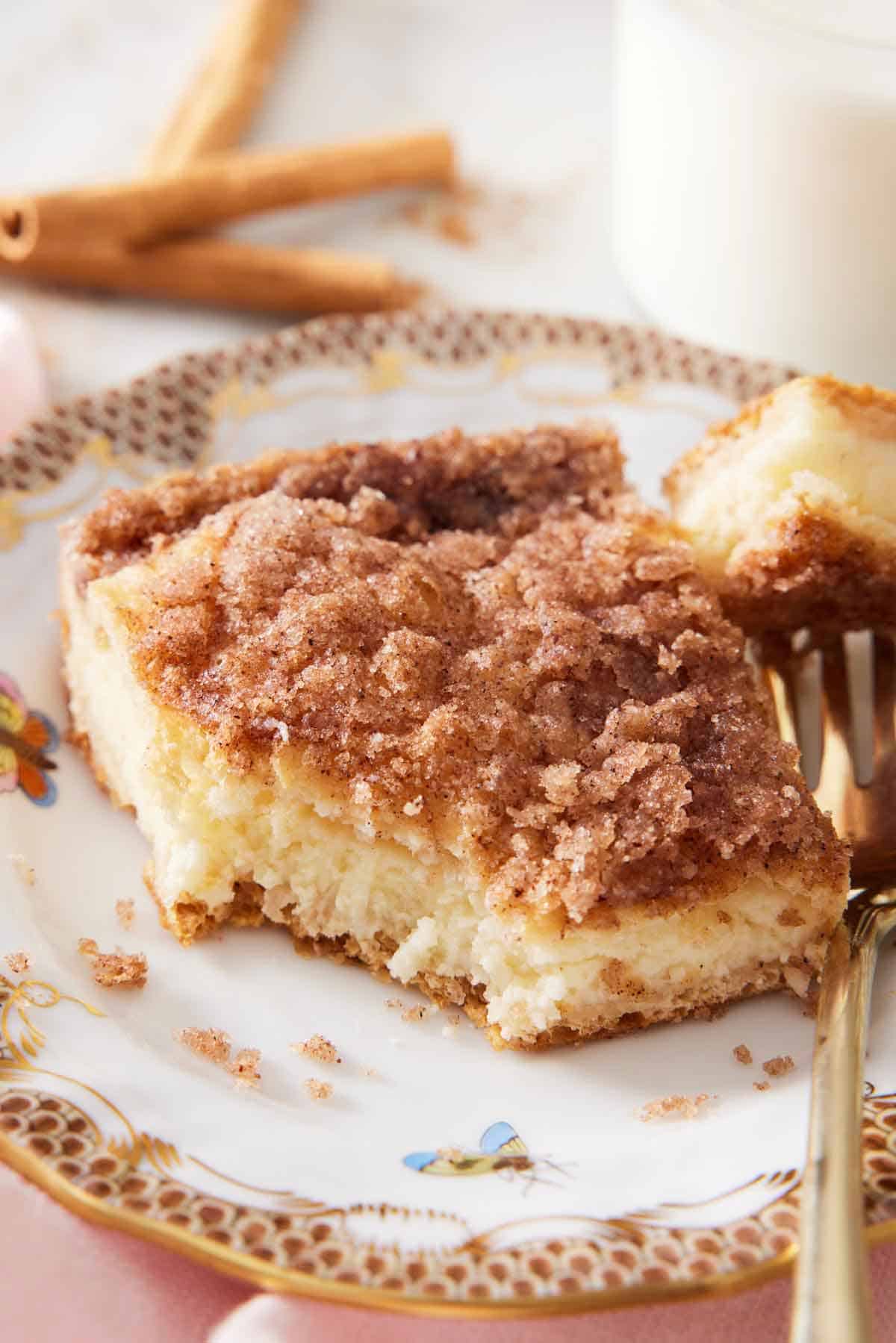 A plate with a slice of sopapilla cheesecake with the corner taken off onto a fork.