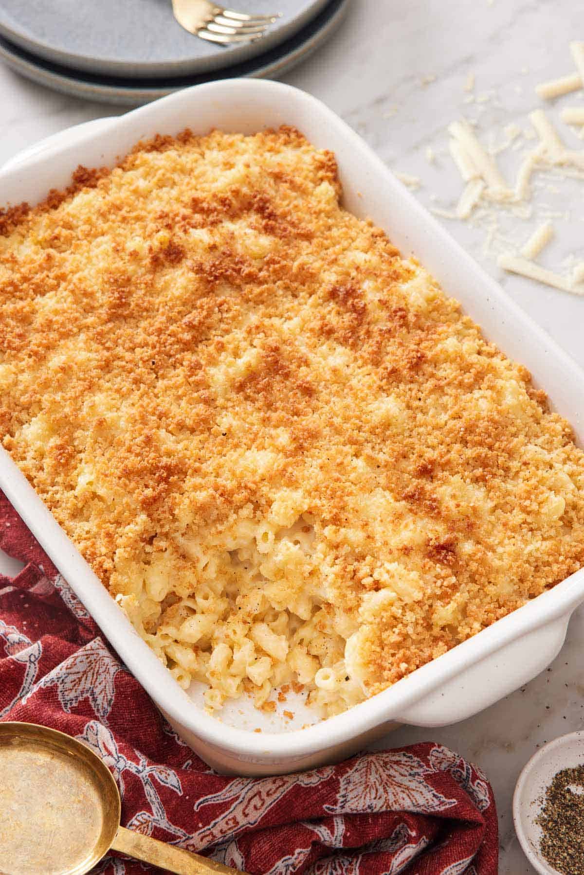 A baking dish of truffle mac and cheese with a scoop taken out.