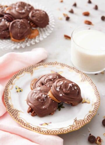 A plate with three turtles on a plate with a glass of milk and additional turtles in the background.