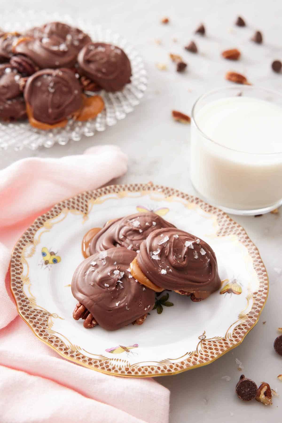 A plate with three turtles on a plate with a glass of milk and additional turtles in the background.
