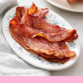 Pinterest graphic of a blue and white platter of air fryer bacon.