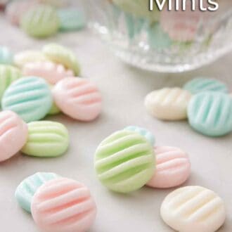Pinterest graphic of cream cheese mints in different colors on a marble surface with a bowl with more in the background.