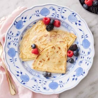 Overhead view of a plate of crepe recipe with fresh berries.