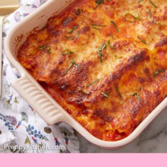 Pinterest graphic of a baking dish of manicotti with ribboned basil on top.