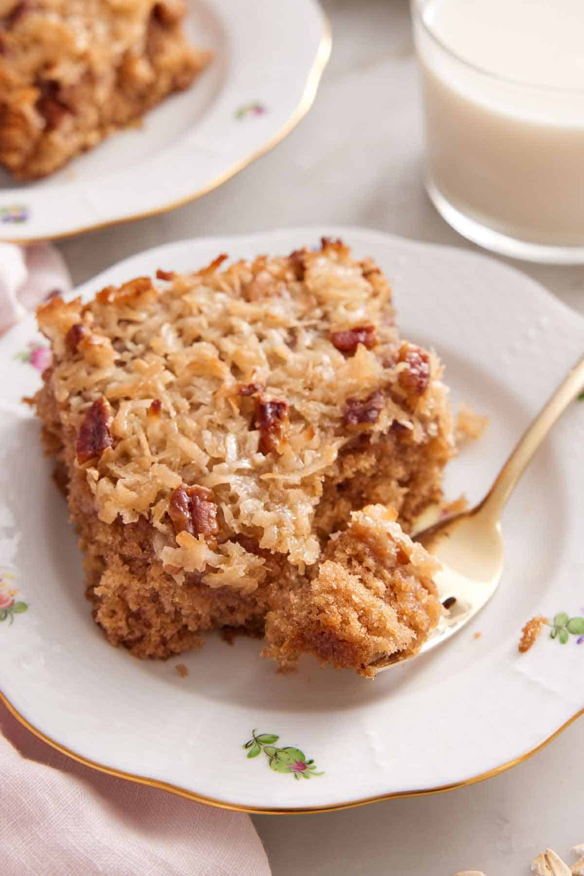 A plate with a piece of oatmeal cake with a fork with the corner piece on it.