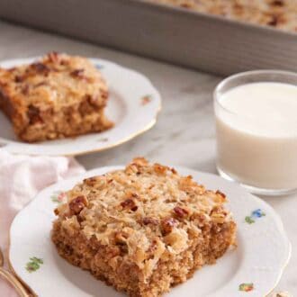 Pinterest graphic of two plated slices of oatmeal cake with a glass of milk and rest of the baking pan in the background.