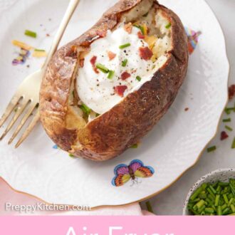 Pinterest graphic of a plate with an air fryer baked potato topped with sour cream, crumbled bacon, chives, and pepper with a fork.