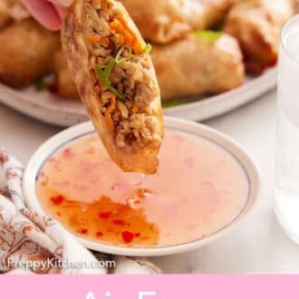 Pinterest graphic of half an air fryer egg roll dipped in sauce.