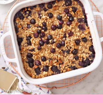 Pinterest graphic of an overhead view of a white baking dish with baked oatmeal with a bowl of blueberries beside it with some scattered.