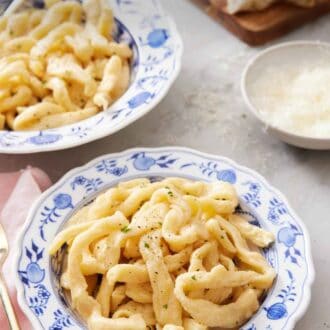 Pinterest graphic of a bowl of cooked egg noodles with a second bowl in the background along with a bowl of parmesan and torn bread.