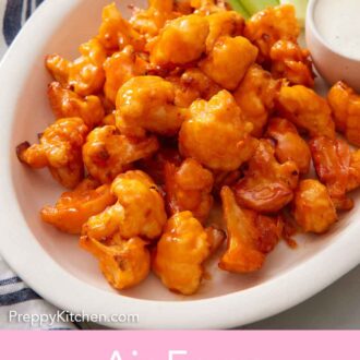 Pinterest graphic of a platter of air fryer buffalo cauliflower with dip and celery sticks.