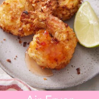 Pinterest graphic of three air fryer coconut shrimp on a plate with sweet chili sauce drizzled on top and a lime wedge on the side.