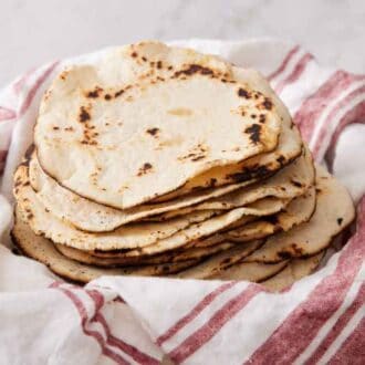 A stack of corn tortillas on a linen napkin.