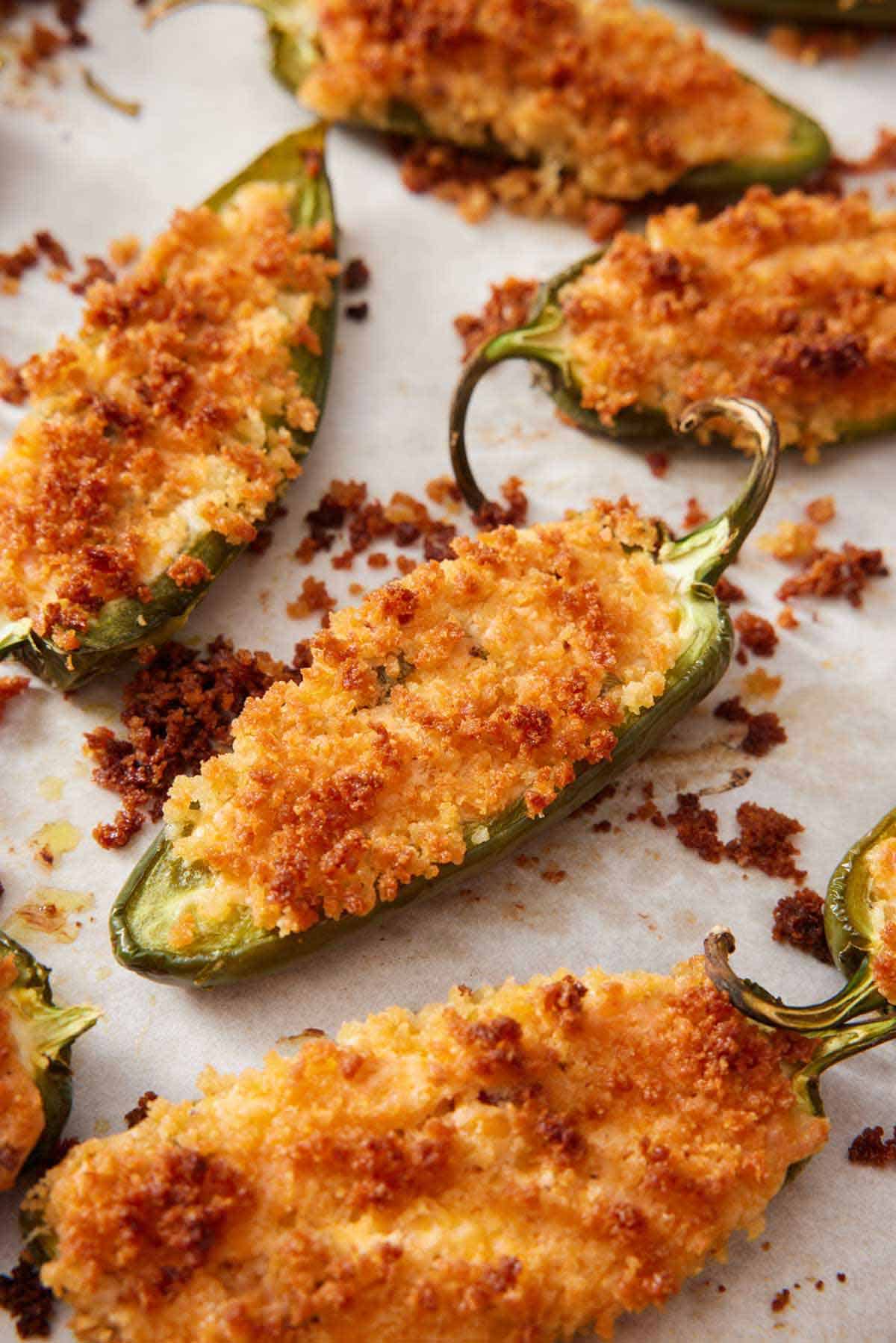 Multiple jalapeno poppers with crispy panko scattered around.
