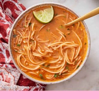 Pinterest graphic of a bowl of sopa de fideo with a spoon and lime inside.