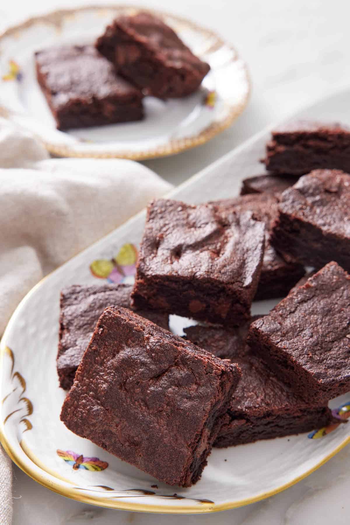 A platter of air fryer brownies with a plate with two pieces in the background.