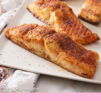 Pinterest graphic of a platter with air fryer salmon with lemon wedges.