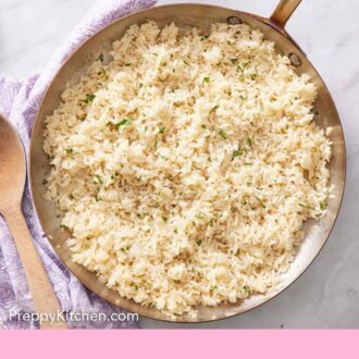 Pinterest graphic of an overhead view of a skillet of rice pilaf with chopped parsley garnish.