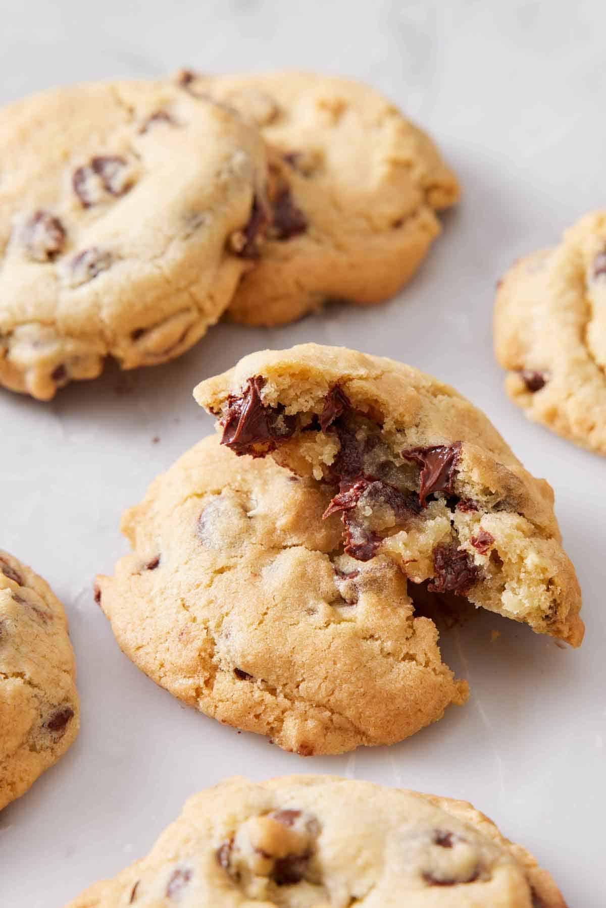 An air fryer cookie torn in half and stacked on top of each other. More cookies surrounding it.