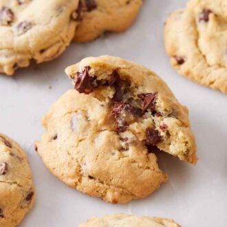 An air fryer cookie torn in half and stacked on top of each other. More cookies surrounding it.