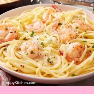 Pinterest graphic of parmesan grated over a plate of shrimp linguine.