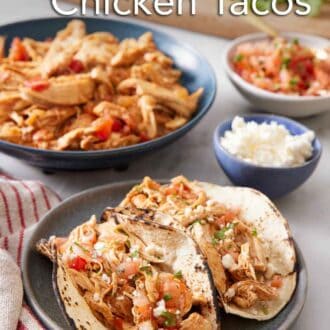 Pinterest graphic of a plate with two Instant Pot chicken tacos with the rest of the components in the background.