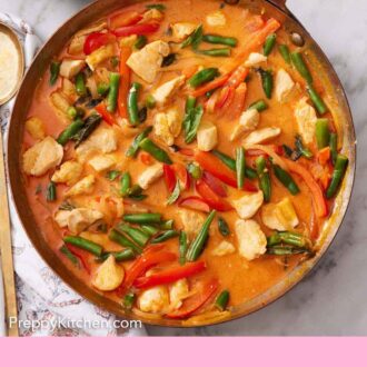 Pinterest graphic of a skillet of Thai red curry with a bowl of rice beside it.