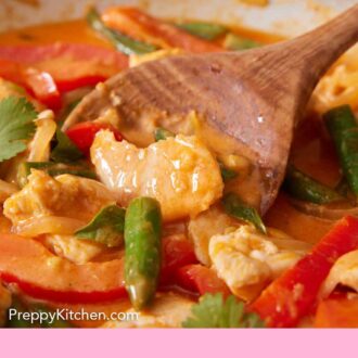 Pinterest graphic of a close view of a wooden spoon scooping Thai red curry in a skillet.