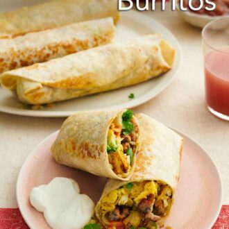 Pinterest graphic of a plate with a breakfast burrito cut in half with sour cream. More breakfast burritos in the background on a platter with sour cream and salsa.