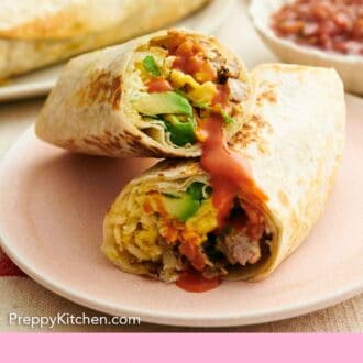 Pinterest graphic of a plate with a breakfast burrito cut in half, one half stacked on top of the other, showing the interior.