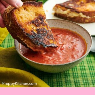 Pinterest graphic of half of a grilled cheese dipped into a bowl of tomato soup.
