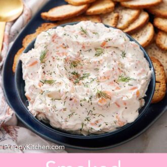 Pinterest graphic of a bowl of smoked salmon dip topped with fresh dill on a platter with crackers.