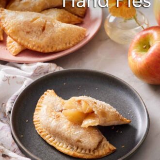 Pinterest graphic of a plate with an air fryer hand pie with a second half leaning on top, showing the interior. More hand pies in the background.