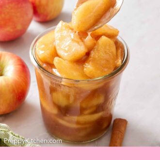 Pinterest graphic of apple pie filling spooned into a jar. Apples in the background.