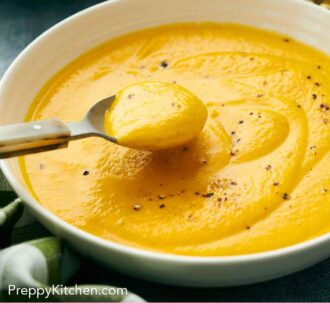 Pinterest graphic of a spoonful of carrot soup lifted from a bowl.