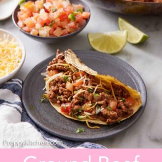 Pinterest graphic of a plate with a ground beef taco topped with cheese, pico de gallo, and cilantro. A skillet with more ground beef, a bowl of pico de gallo, and lime wedges in the background.