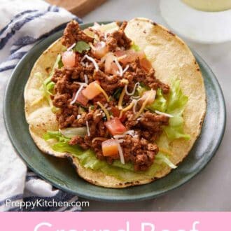 Pinterest graphic of a plate with an open faced ground beef taco with lettuce, pico de gallo, shredded cheese, and cilantro.