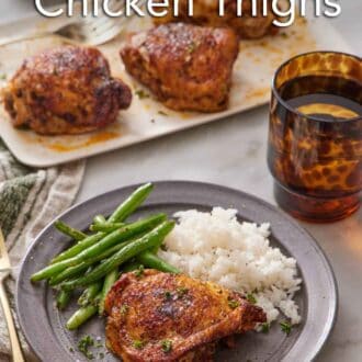 Pinterest graphic of a plate with an Instant Pot chicken thigh with rice and green beans. More chicken thighs in the back on a platter along with a drink.