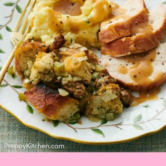 Pinterest graphic of a plate with sausage stuffing, sliced turkey, and mashed potatoes with gravy on top.