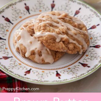 Pinterest graphic of a plate with two brown butter wassail cookies with icing drizzled on top.