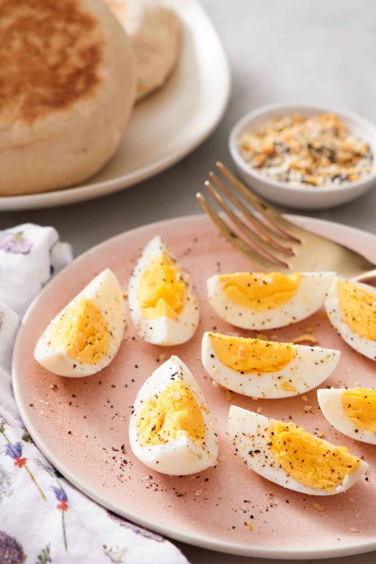 A close up view of a plate of quartered air fryer hard boiled eggs topped with salt and pepper.