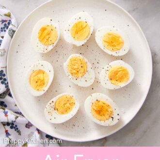 Pinterest graphic of an overhead view of a platter of air fryer hard boiled eggs cut in half topped with pepper.