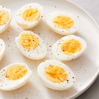 A plate of halved air fryer hard boiled eggs topped with pepper.