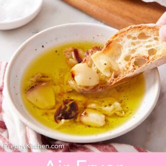 Pinterest graphic of a piece of bread dipped into oil with air fryer roasted garlic.