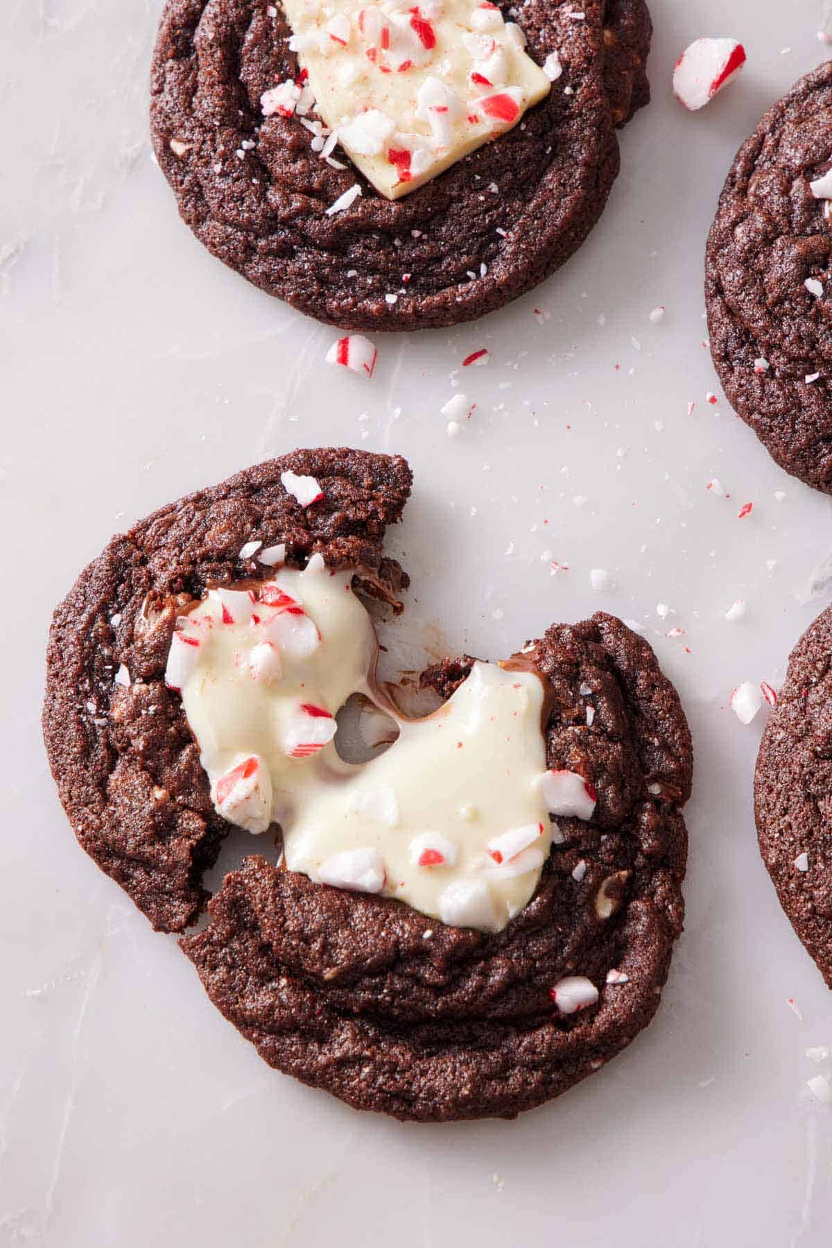 An overhead view of a chocolate peppermint bark cookie cut in half and slightly pulled apart.