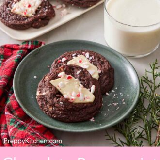 Pinterest graphic of a plate with two chocolate peppermint bark cookies. A glass of milk and platter with more cookies in the background.
