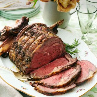 Pinterest graphic of a platter with a prime rib with a few slices cut in front of it.